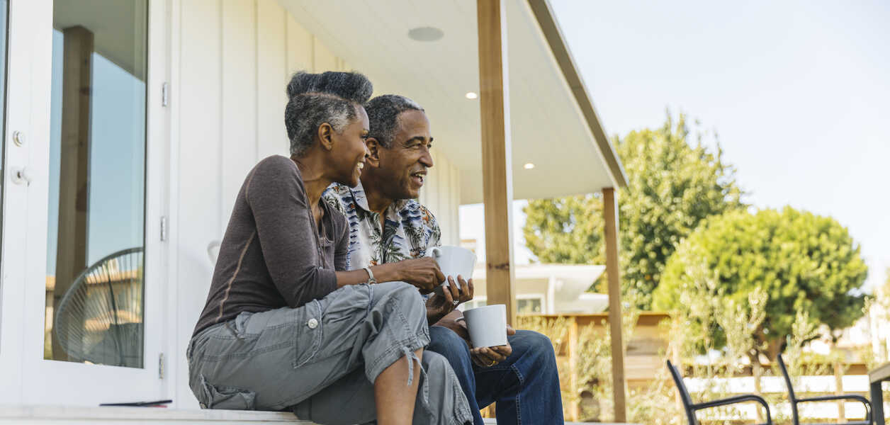 Retired couple sitting on doorstep 