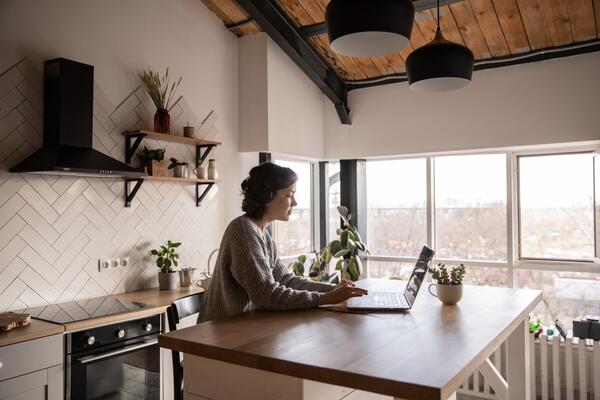 Femme travaillant à un ordinateur portable dans une cuisine