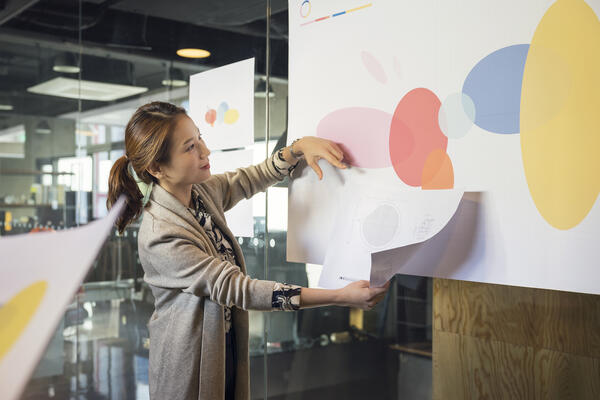 Woman presenting large illustration in meeting