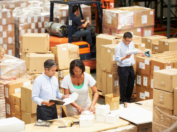 Group of people in warehouse preparing boxes for shipping