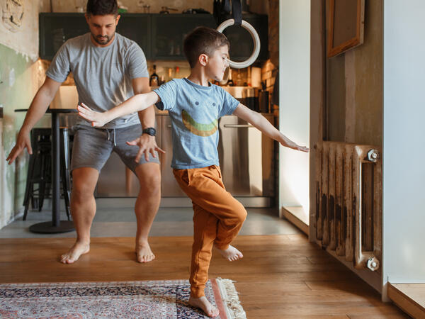 Father and son dancing in the living room