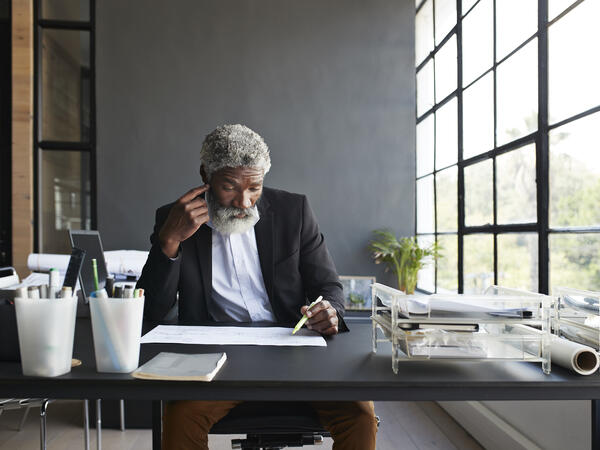 Homme assis à son bureau, lisant des documents