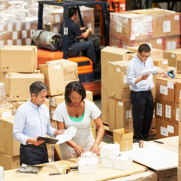 Group of people in warehouse preparing boxes for shipping